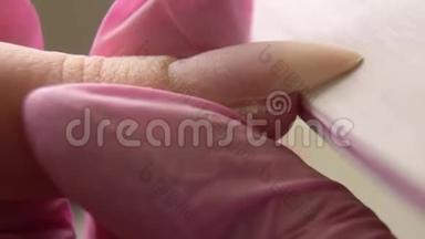 美甲专家抛光指甲给客户。 指甲美容师在美甲沙龙给女人整理指甲。 女人正在